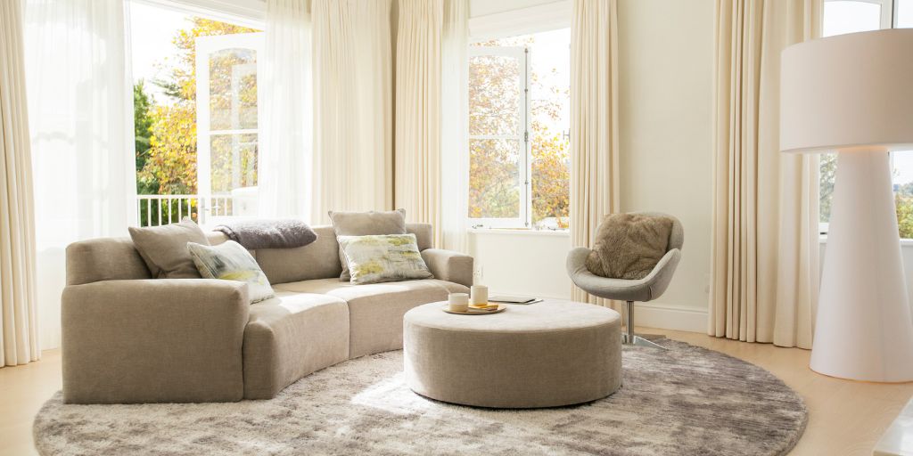 beautiful sitting area in home with curved beige couch